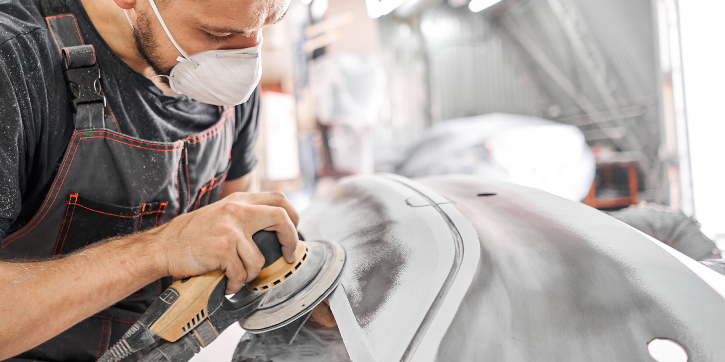 Man Sanding A Car Body Panel